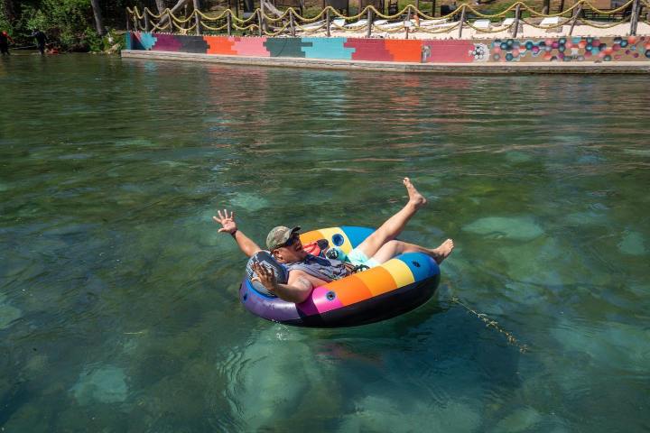 a little girl riding on the back of a boat in the water