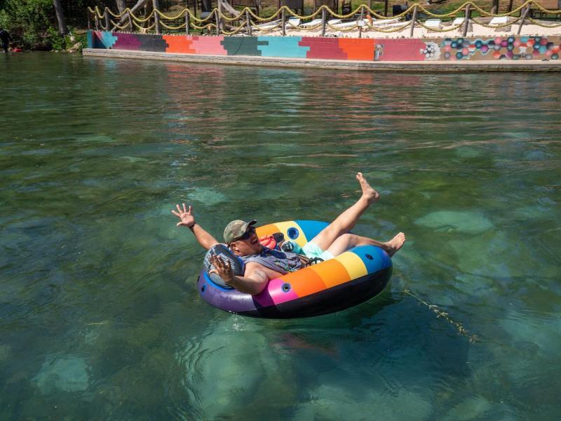 a little girl riding on the back of a boat in the water